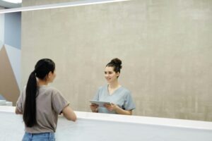 Doctora explicando a una paciente cómo fijar el precio en las clínicas dentales según el tratamiento